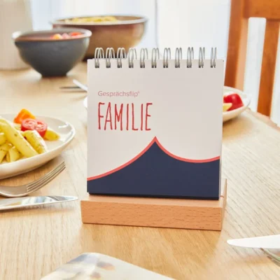 Das Cover vom Gesprächsflp FAMILIE. Der flip steht auf dem gedeckten Esstisch